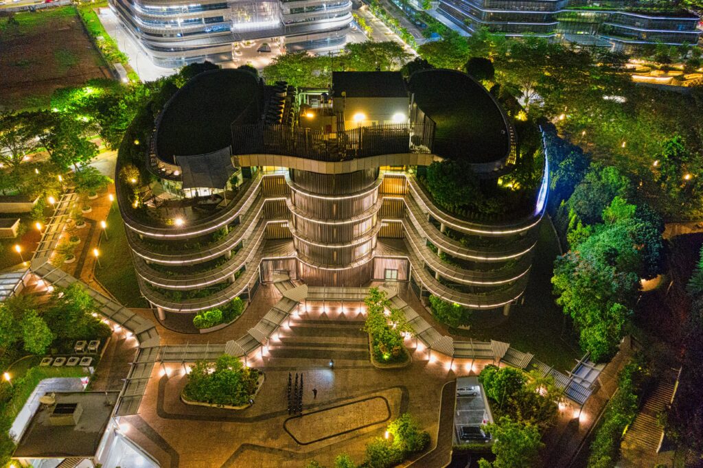 A stunning night aerial view of a modern architectural building in Banten, Indonesia, illuminated with vibrant lights.
